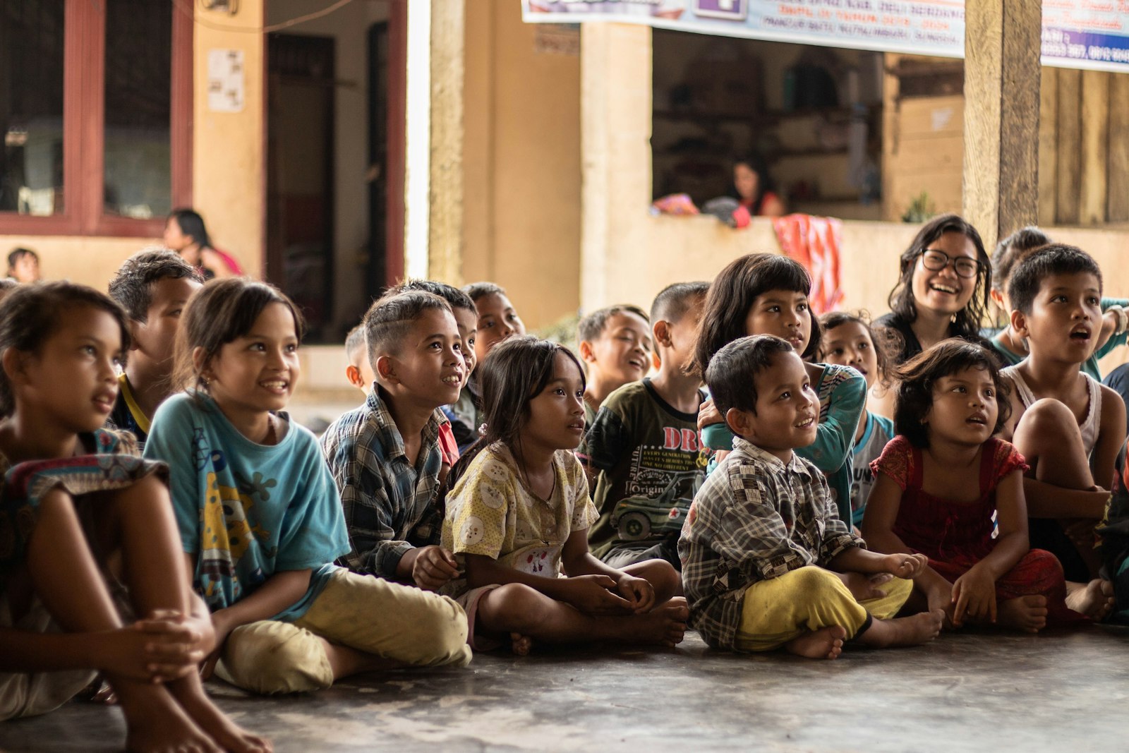 A group of children sitting on the ground together