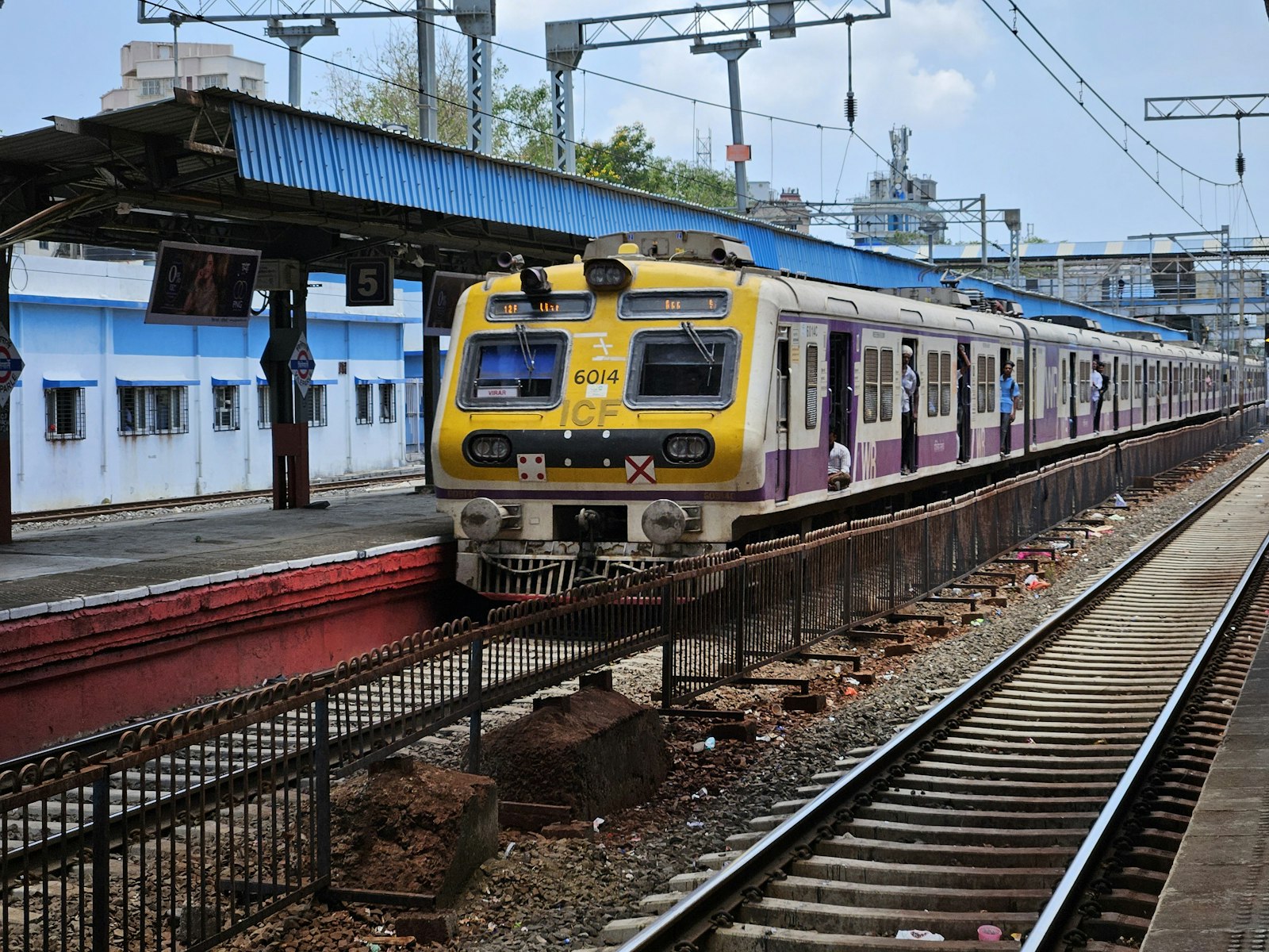 A local train arriving at a railway station platform in Mumbai